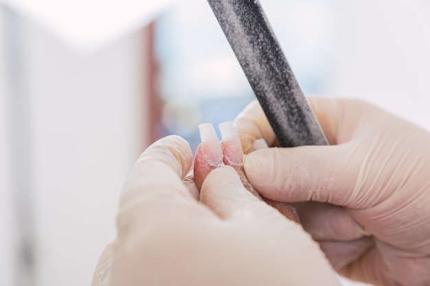 Mains de l'artiste de manucure. La manucure vérifie les ongles. Concept de beauté et de santé.