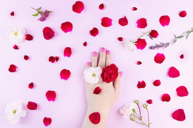 Mains de beauté avec des fleurs de maquillage