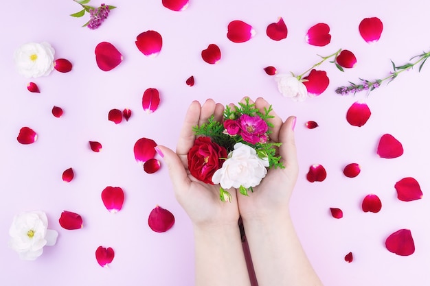 Mains de beauté avec des fleurs de maquillage