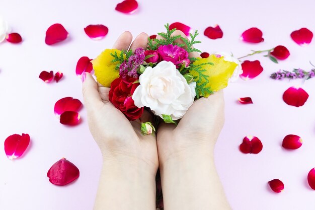 Mains de beauté avec des fleurs de maquillage