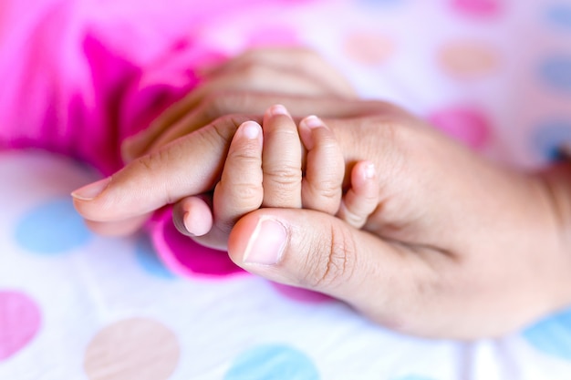 Photo mains de bébé et maman le tenant