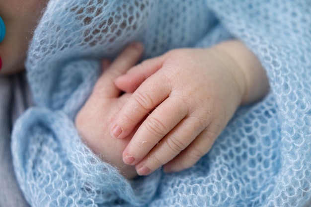 Les mains d'un bébé sont tenues par une main