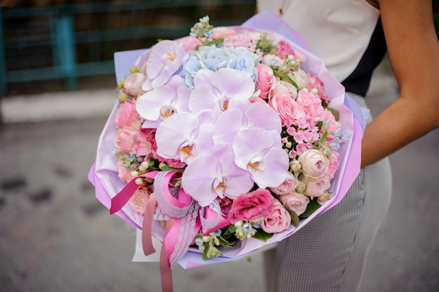 Mains avec une belle et douce composition de fleurs roses