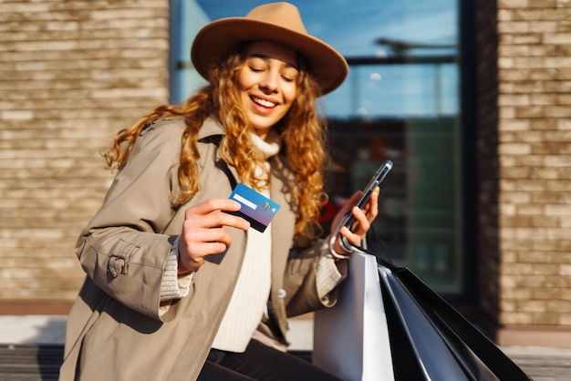 Les mains d'une belle femme avec une carte de crédit téléphonique Concept d'achat en ligne Concept de style de vie