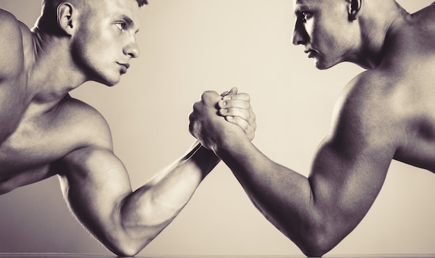 Photo mains ou bras d'homme. main musclée. bras de fer serrés. rivalité, gros plan du bras de fer masculin. deux mains. hommes musclés mesurant les forces, les bras. lutte à la main, compétition. noir et blanc.