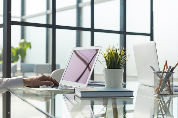 Mains d'un cadre travaillant sur son ordinateur portable au bureau