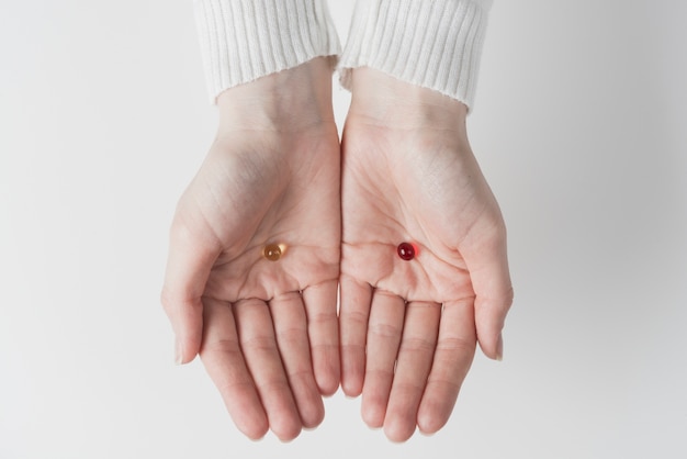 Photo mains avec des capsules rouges et jaunes