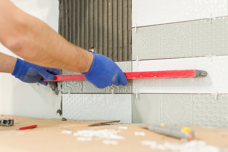 Mains de carreleur installer des carreaux de céramique sur le mur