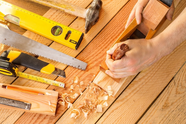 Mains d'un charpentier raboté bois, lieu de travail