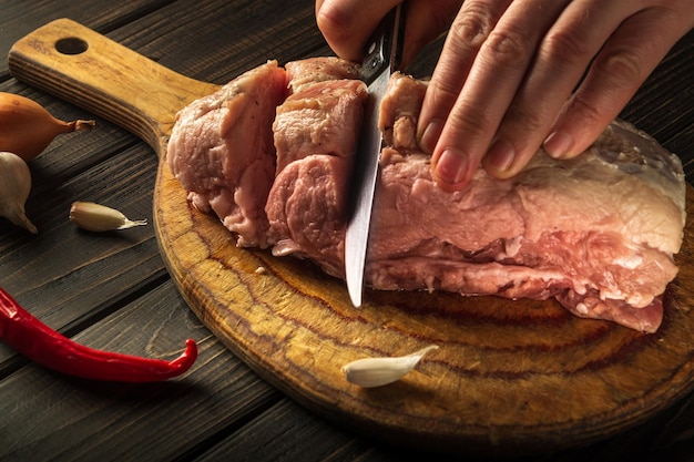 Mains d'un chef avec un couteau dans la cuisine