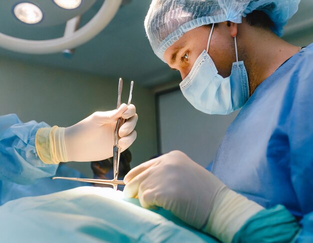 Photo les mains d'un chirurgien dans une salle d'opération en gros plan stables et précises mains gantées délicatement manipulées