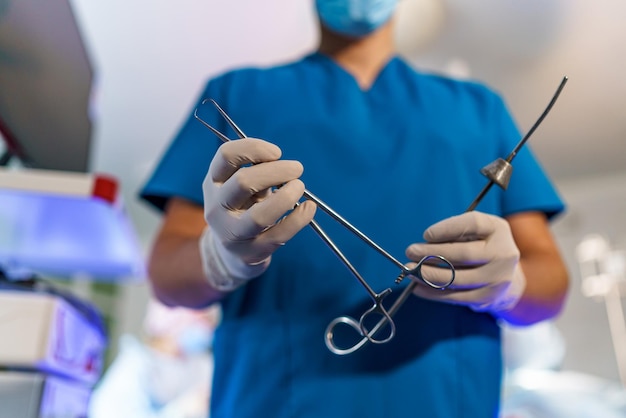 Mains de chirurgiens prenant des pinces à ciseaux ou des instruments chirurgicaux Opération à l'hôpital Concept médical de chirurgie de cas d'urgence