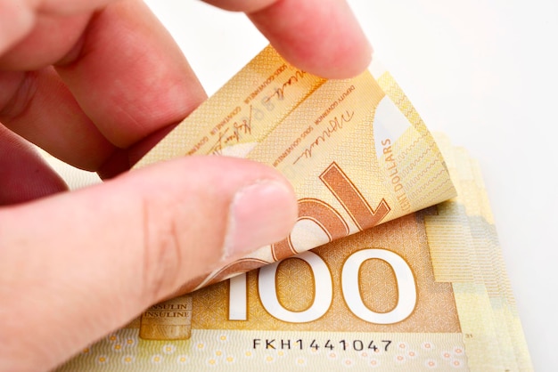 Mains comptant les billets de 100 dollars canadiens