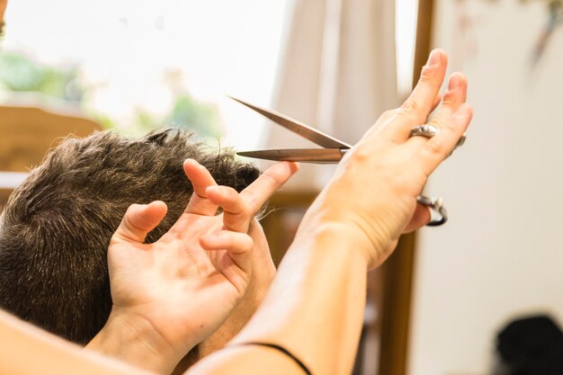 Mains coupant les cheveux d&#39;un homme