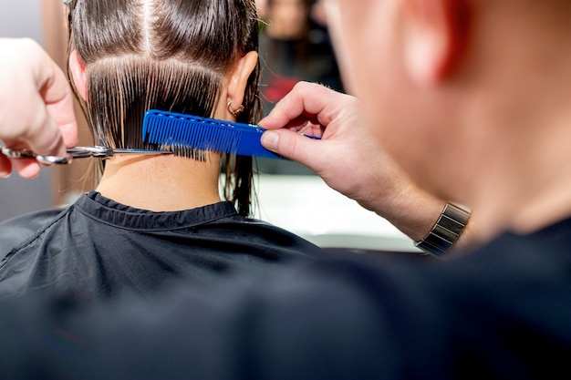 Photo mains coupe les cheveux de la femme