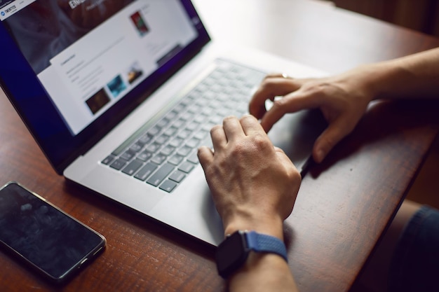 Photo des mains coupées à l'aide d'un ordinateur portable sur la table