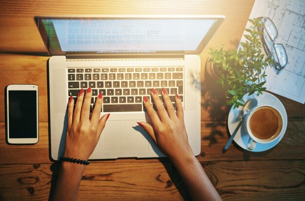 Photo des mains coupées à l'aide d'un ordinateur portable sur la table