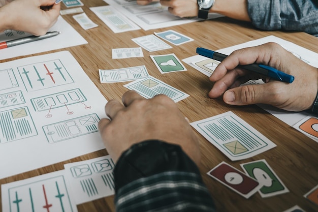 Photo des mains coupées de collègues avec des papiers sur le bureau.