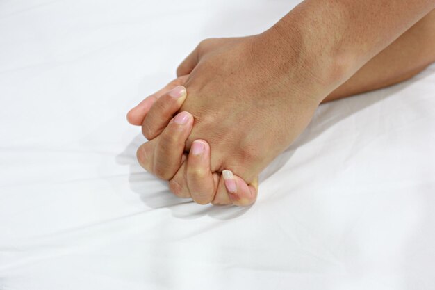 Photo des mains coupées d'une femme sur le lit