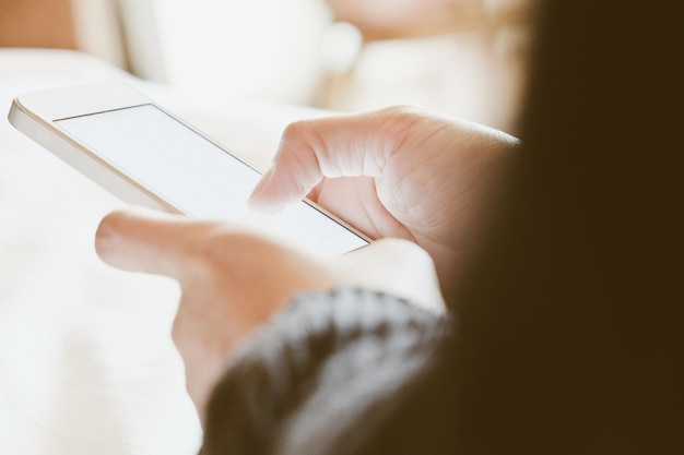 Des mains coupées d'une femme utilisant un smartphone