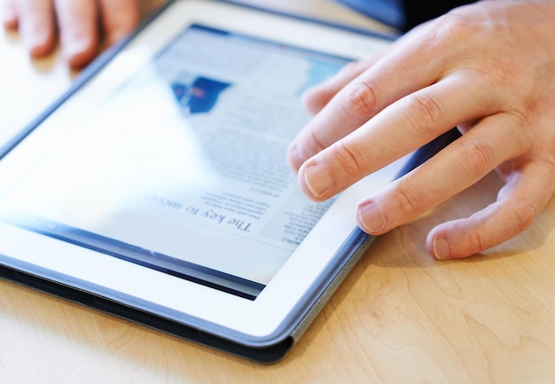 Photo des mains coupées d'une femme utilisant une tablette numérique sur la table