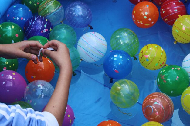 Photo des mains coupées d'un garçon tenant un ballon dans une piscine