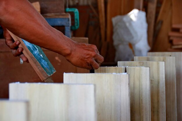 Photo mains coupées d'un homme travaillant sur le bois dans un atelier