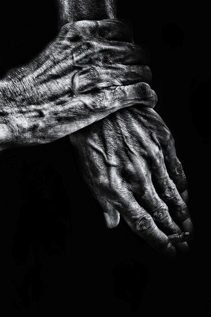 Photo des mains coupées d'hommes âgés sur un fond noir