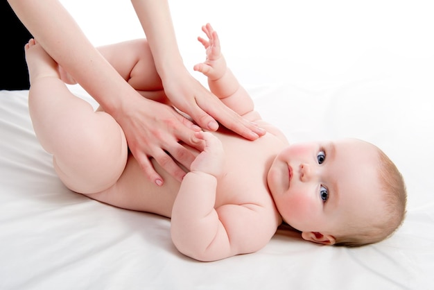 Des mains coupées d'une mère avec sa fille allongée sur le lit.