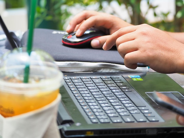 Photo des mains coupées avec un ordinateur portable au café.