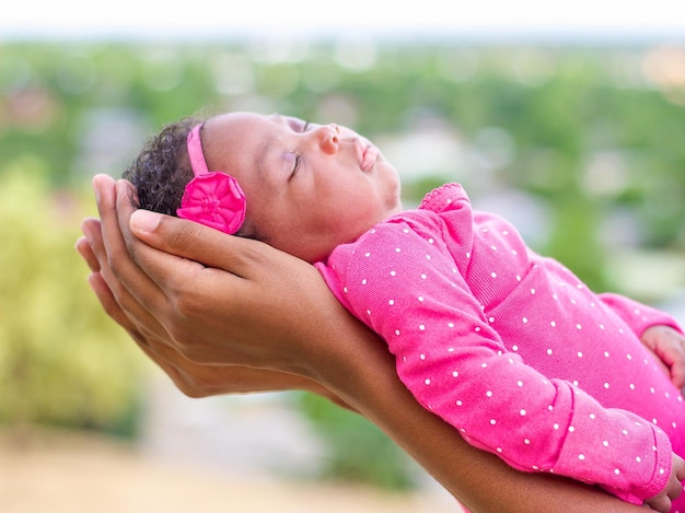 Photo des mains coupées d'un parent tenant un bébé