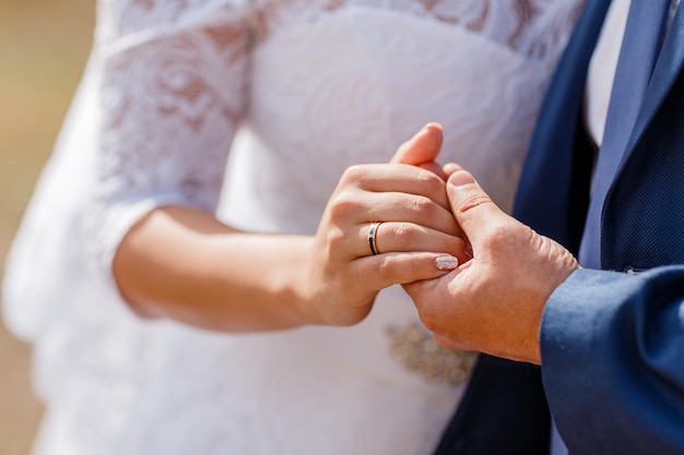 Mains de couples nouvellement mariés avec des anneaux de mariage