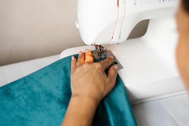 Mains en cours de couture Les mains des femmes cousent du tissu sur une machine à écrire passe-temps à la maison