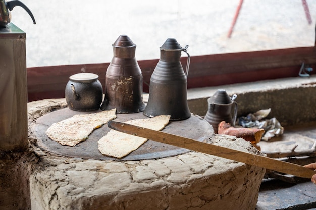 Mains de cuisinier turc préparant du gozleme de pommes de terre et de fromage sur des crêpes farcies traditionnelles au poêle chaud