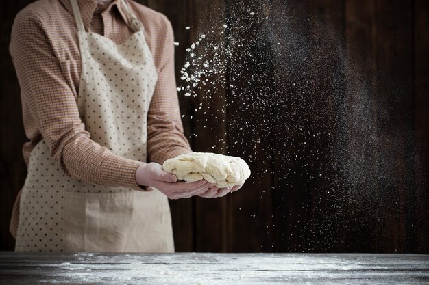 Mains, cuisson de la pâte sur du bois foncé