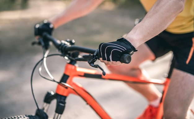 Mains dans les gants sur le guidon du vélo