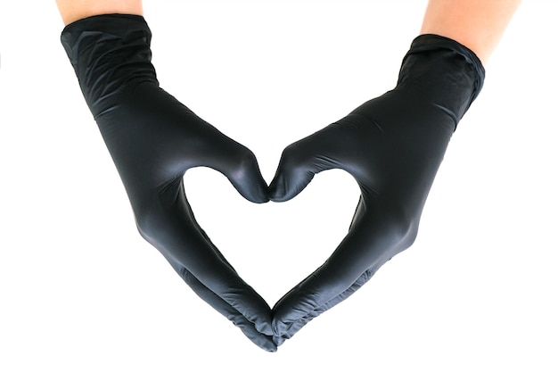 Mains dans des gants noirs en forme de coeur sur fond blanc isolé. Le concept de cosmétologie, d'épilation, de soins de santé