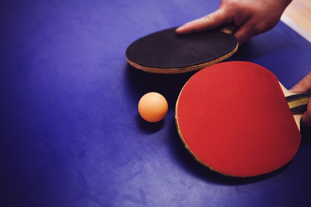 Mains avec deux raquettes de tennis de table ou de ping-pong