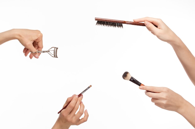 Mains avec différents produits de maquillage