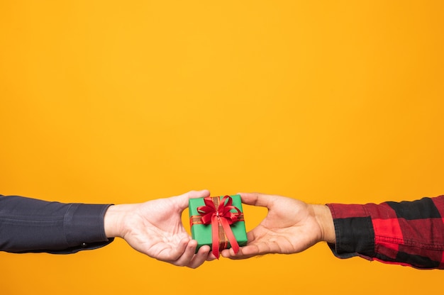 Photo mains donnant une boîte-cadeau de noël