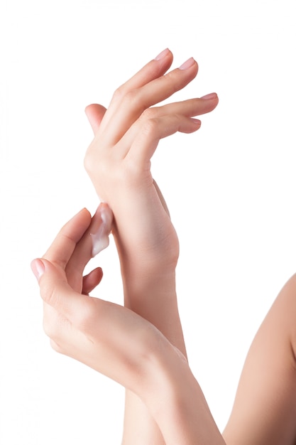 Des mains douces parfaites avec la goutte de crème hydratante. jeune fille portant de la crème pour les mains