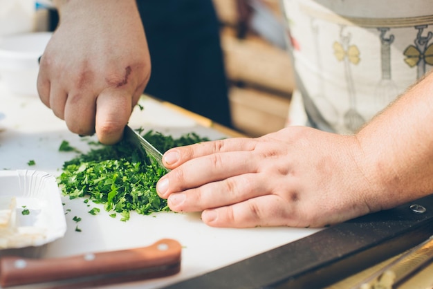 Mains du couteau et des verts de cuisinier