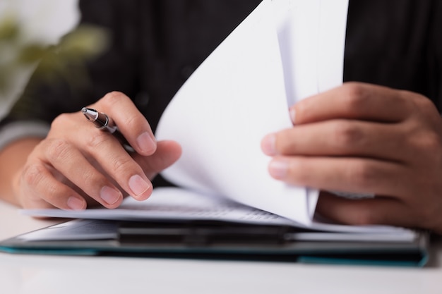 Les mains du directeur d'homme d'affaires écrivant à l'entreprise sur le bureau pour lire la signature dans la paperasse