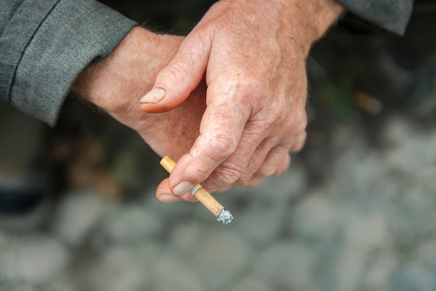 Les mains du fumeur se bouchent avec une cigarette Vue d'en haut