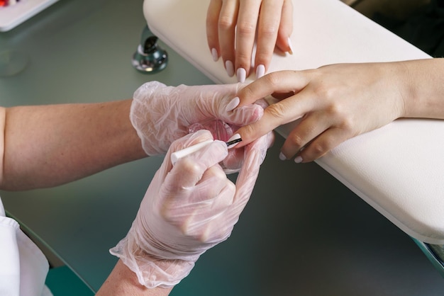 Mains du maître de manucure et vue de dessus du client maître du service des ongles soins des ongles en gros plan par manucure sp...