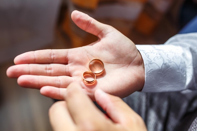 Mains du marié avec anneaux pensées de mariage