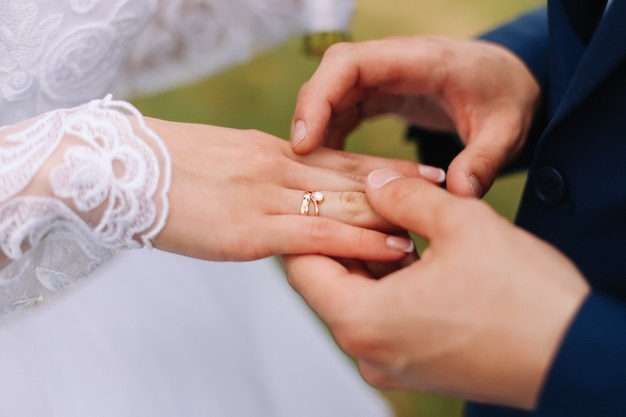 Mains du marié et de la mariée avec anneaux de mariage