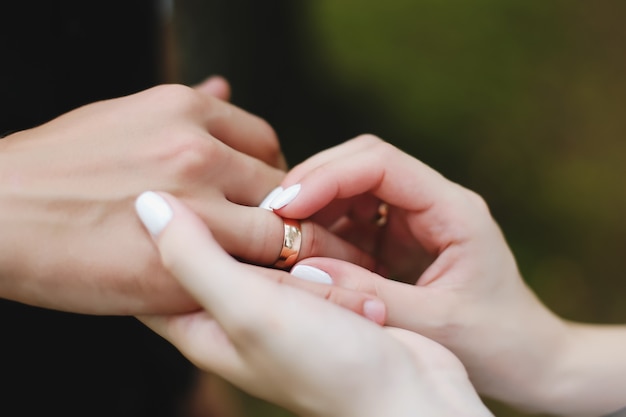 Mains du marié et de la mariée avec anneaux