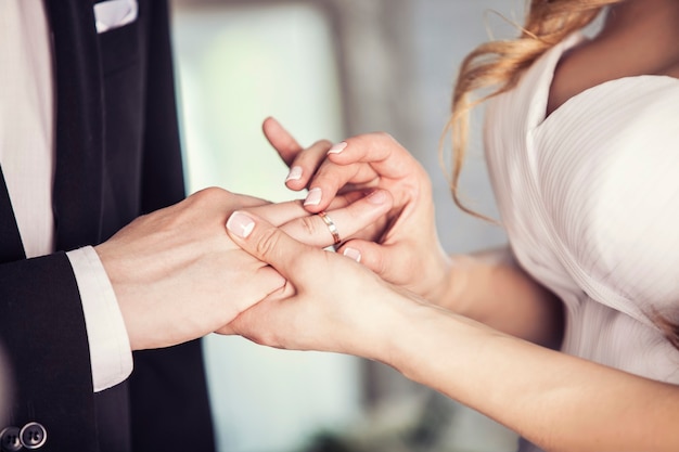 Les mains du marié et de la mariée portent une bague au doigt le jour de la cérémonie de mariage. Or, symbole, religion, amour.