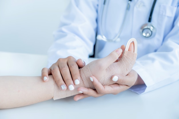 Les mains du médecin tenant le patient dans un accident de bras pour encourager et expliquer les résultats de l'examen de santé.